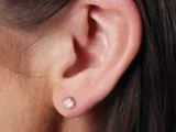 un gros plan sur l'oreille d'une femme portant une paire de boucles d'oreilles