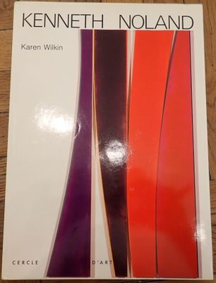 the book is on a wooden table with a red and purple striped design