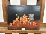 un tableau représentant des raisins et un verre posé sur une chaise en bois