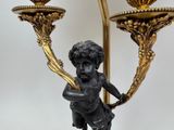 a statue of a boy holding a candelier on a table
