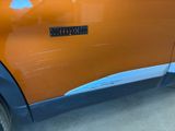an orange car with a sticker on the side of it