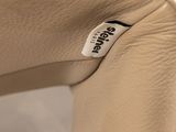 beige leather chair with a label on the back of the chair