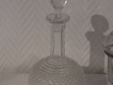 a small glass bottle and a small glass jar on a table