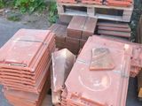 de nombreuses piles de briques rouges sur une palette