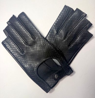 une paire de gants en cuir noir posée sur une table blanche