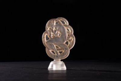 a close up of a glass sculpture of a woman on a pedestal