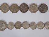 a group of five different coins sitting on top of a white surface