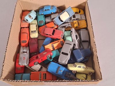 de nombreuses petites voitures dans une boîte en carton posée sur une table