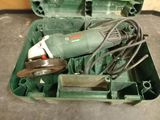 a green box with tools in it sitting on the floor