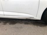 a white car that is parked on the side of the road