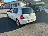 une voiture blanche garée dans un parking à côté d'un bâtiment