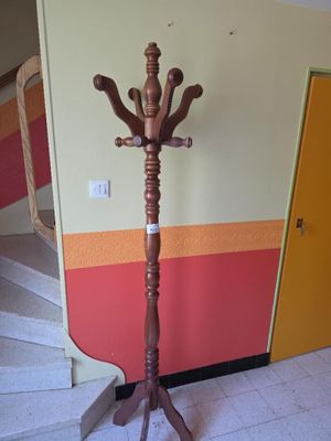 a wooden coat stand in the corner of a room