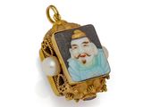 an image of a gold and enamel portrait of a man with a pearl bead