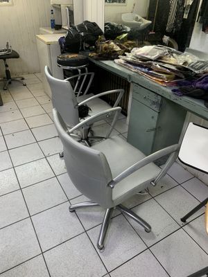 une photo d'un salon de coiffure avec des fauteuils et un comptoir