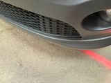 a close up of a car ' s front bumper with a red line painted on it
