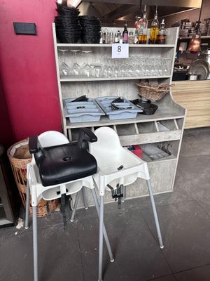 une table avec une chaise et une étagère sur laquelle sont posées des bouteilles