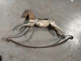 un cheval à bascule en bois posé sur une surface métallique