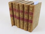 trois livres sont empilés sur une surface blanche
