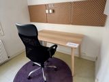 a desk and chair in a room with a purple rug