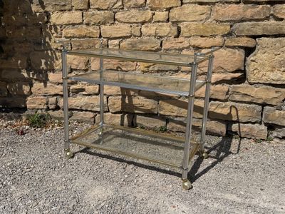 a metal cart that is sitting in front of a stone wall