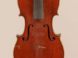 an old violin sitting on top of a white surface