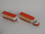 deux camions miniatures posés l'un à côté de l'autre sur une surface blanche