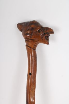 an old wooden walking stick with a cat head carved into it