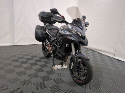 une moto qui est garée dans une pièce dont le sol est en damier