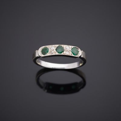 une bague en or blanc sertie d'émeraudes et de diamants