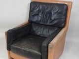 a black leather chair with a wooden frame on a white background