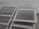 several metal grates sitting on top of a cement floor next to a wall