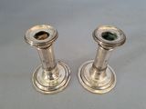 pair of silver candlesticks on a white surface