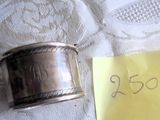 une petite bague en argent posée sur une table, avec un mot dessus