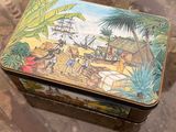 a tin box with a painting on it sitting on a table