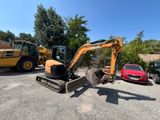 une petite excavatrice garée sur un parking