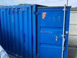 un conteneur bleu posé au milieu d'un parking