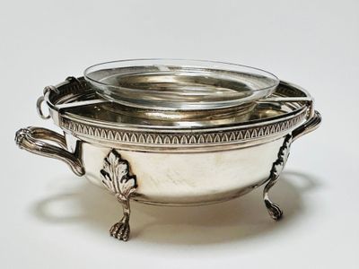 a silver bowl with a lid on a white surface