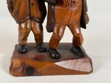 a wooden statue of two men standing next to each other