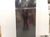 a black refrigerator sitting on a pallet in a warehouse
