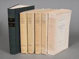 three books are stacked on top of each other on a gray surface