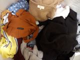 a pile of clothes sitting on top of a bed