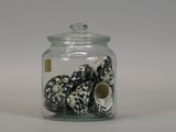 a glass jar filled with donuts sitting on a table