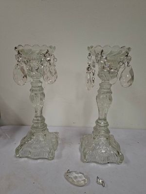 two clear glass candlesticks on a table