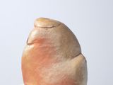a small sculpture on a white pedestal on a white surface