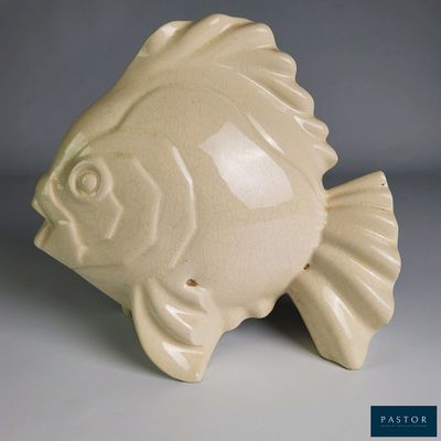 un petit poisson en céramique posé sur une table