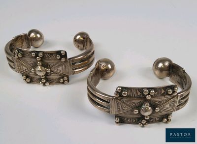 deux bracelets manchette en argent ornés de perles, posés sur un fond blanc