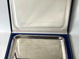a silver plate in a blue case on a white surface