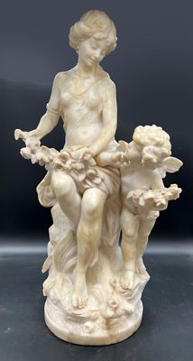 une image représentant une statue d'une femme assise sur un rocher avec deux enfants