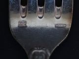 a close up of a metal fork with holes in it