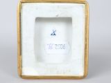 a close up of a white and gold frame with a blue star on it